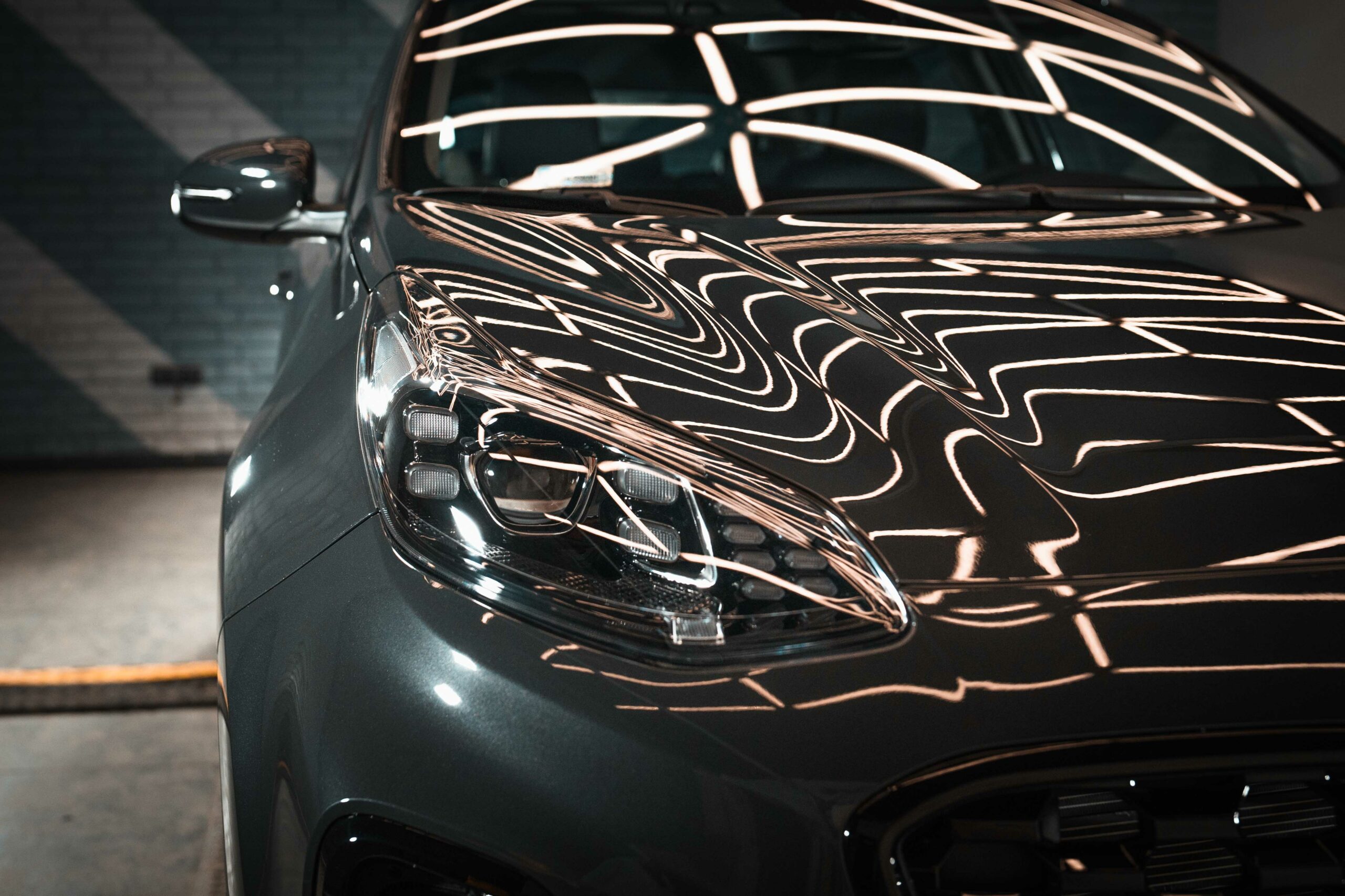 Samochód Kia Sportage z refleksami światła na masce